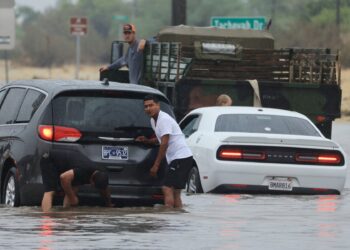 Los automovilistas enfrentan una carretera inundada y vehículos atascados durante las fuertes lluvias de la tormenta tropical Hilary en Palm Springs, California, el 20 de agosto de 2023. - Fuertes lluvias azotaron California el 20 de agosto cuando la tormenta tropical Hilary se acercaba desde México, trayendo advertencias de vida potencial. amenaza de inundaciones en el típicamente árido suroeste de los Estados Unidos. (Foto de DAVID SWANSON / AFP)
