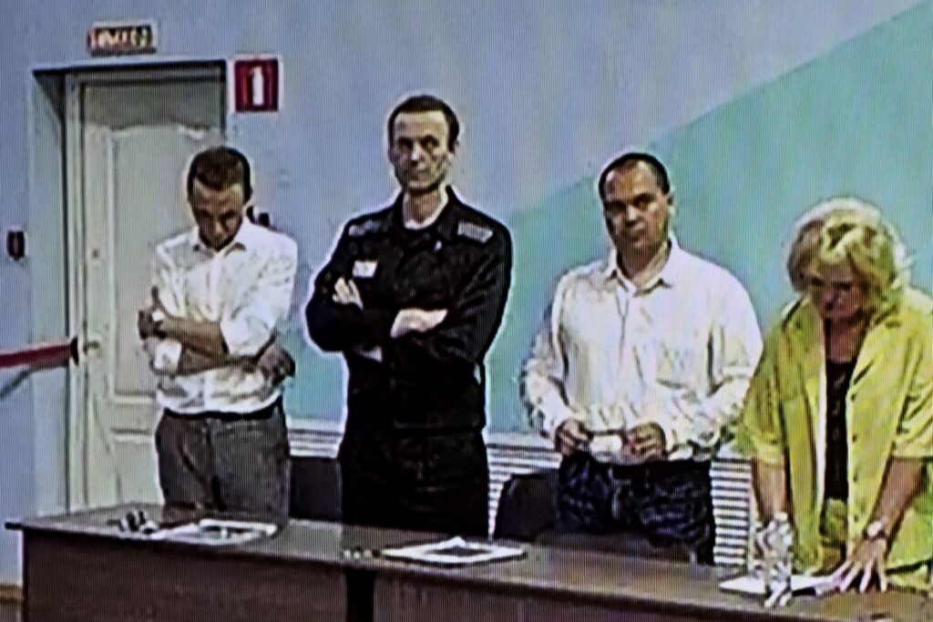 Una pantalla muestra a la figura de la oposición rusa Alexei Navalny (2L), ya encarcelada, mientras escucha su veredicto sobre una serie de cargos de extremismo en la colonia penal IK-6, una prisión de máxima seguridad a unos 250 kilómetros (155 millas) al este de Moscú. en el asentamiento de Melekhovo en la región de Vladimir el 4 de agosto de 2023.