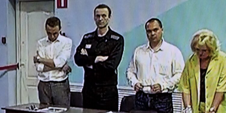 Una pantalla muestra a la figura de la oposición rusa Alexei Navalny (2L), ya encarcelada, mientras escucha su veredicto sobre una serie de cargos de extremismo en la colonia penal IK-6, una prisión de máxima seguridad a unos 250 kilómetros (155 millas) al este de Moscú. en el asentamiento de Melekhovo en la región de Vladimir el 4 de agosto de 2023.