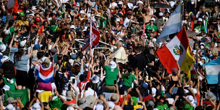 Los peregrinos animan y ondean banderas cuando el Papa Francisco llega a la ceremonia de bienvenida de la reunión de jóvenes católicos de la Jornada Mundial de la Juventud (JMJ), en el Parque Eduardo VII en Lisboa el 3 de agosto de 2023.