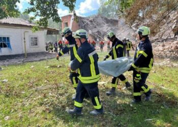 This handout photograph taken and released by the Ukrainian State Emergency Service on August 23, 2023 shows rescuers carrying a victim's body out of a destroyed school  following a Russian strike, in the town of Romny, Sumy region, amid the Russian invasion of Ukraine. - The death toll in a Russian strike on a school in the Ukrainian village of Romny, in the north-eastern region of Sumy, has risen to four, the authorities said on August 23, 2023. (Photo by Handout / Ukrainian State Emergency Service / AFP) / RESTRICTED TO EDITORIAL USE - MANDATORY CREDIT "AFP PHOTO / UKRAINIAN STATE EMERGENCY SERVICE"  - NO MARKETING NO ADVERTISING CAMPAIGNS - DISTRIBUTED AS A SERVICE TO CLIENTS - RESTRICTED TO EDITORIAL USE - MANDATORY CREDIT "AFP PHOTO / Ukrainian State Emergency Service"  - NO MARKETING NO ADVERTISING CAMPAIGNS - DISTRIBUTED AS A SERVICE TO CLIENTS /
