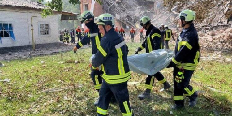 This handout photograph taken and released by the Ukrainian State Emergency Service on August 23, 2023 shows rescuers carrying a victim's body out of a destroyed school  following a Russian strike, in the town of Romny, Sumy region, amid the Russian invasion of Ukraine. - The death toll in a Russian strike on a school in the Ukrainian village of Romny, in the north-eastern region of Sumy, has risen to four, the authorities said on August 23, 2023. (Photo by Handout / Ukrainian State Emergency Service / AFP) / RESTRICTED TO EDITORIAL USE - MANDATORY CREDIT "AFP PHOTO / UKRAINIAN STATE EMERGENCY SERVICE"  - NO MARKETING NO ADVERTISING CAMPAIGNS - DISTRIBUTED AS A SERVICE TO CLIENTS - RESTRICTED TO EDITORIAL USE - MANDATORY CREDIT "AFP PHOTO / Ukrainian State Emergency Service"  - NO MARKETING NO ADVERTISING CAMPAIGNS - DISTRIBUTED AS A SERVICE TO CLIENTS /
