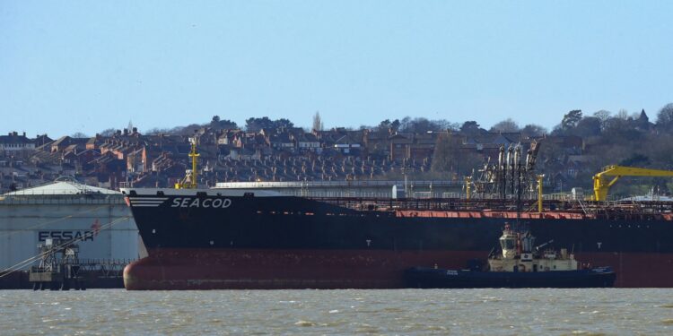 Una fotografía tomada el 5 de marzo de 2022 muestra el barco de bandera alemana "Seacod" atracado cerca de la refinería de petróleo Stanlow, en Cheshire, noroeste de Inglaterra, mientras los estibadores se negaban a descargar el petróleo ruso que transportaba. Los portuarios británicos se negaron a descargar petróleo ruso de un petrolero y pidieron el 5 de marzo de 2022 al gobierno que cerrara una "laguna jurídica" en las sanciones que permitían a los barcos con bandera extranjera entregar el combustible. El Seacod está actualmente amarrado cerca de la refinería de Stanlow en el noroeste de Inglaterra, y los sindicatos dicen que su carga no está cubierta por una prohibición para los buques rusos porque tiene bandera alemana. (Foto de Lindsey Parnaby / AFP)