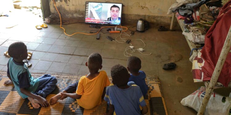 Los niños desplazados que huyeron de la violencia actual de dos generales sudaneses rivales ven la televisión en una sala dentro de la universidad de Al-Jazira, transformada en un refugio improvisado, en Al-Hasahisa, al sur de Jartum, el 8 de julio de 2023. - Durante casi tres meses , las RSF comandadas por Mohamed Hamdan Daglo han luchado contra el ejército regular bajo el mando del general Abdel Fattah al-Burhan en una guerra que se ha cobrado la vida de al menos 3.000 personas y ha desplazado a millones. (Foto de - / AFP)
