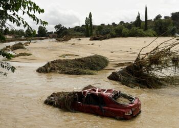 This photograph shows a destroyed car in the middle of a river in the town of Aldea del Fresno, in the Madrid region on September 4, 2023, as a man was reported missing after his vehicle was swept away by an overflowing river during heavy rains, according to Madrid's emergency services. - Affected for months by a historic drought, Spain has been hit by torrential rain that left two people dead and one missing on September 4. This meteorological phenomenon, known as the "Dana" ("isolated high-level depression" in Spanish), began on September 3 afternoon and continued into the night, particularly in Madrid and Castilla-La-Mancha, where torrents of water poured down. (Photo by Oscar DEL POZO CAÑAS / AFP)