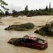 This photograph shows a destroyed car in the middle of a river in the town of Aldea del Fresno, in the Madrid region on September 4, 2023, as a man was reported missing after his vehicle was swept away by an overflowing river during heavy rains, according to Madrid's emergency services. - Affected for months by a historic drought, Spain has been hit by torrential rain that left two people dead and one missing on September 4. This meteorological phenomenon, known as the "Dana" ("isolated high-level depression" in Spanish), began on September 3 afternoon and continued into the night, particularly in Madrid and Castilla-La-Mancha, where torrents of water poured down. (Photo by Oscar DEL POZO CAÑAS / AFP)