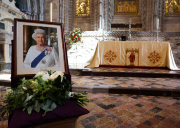 Flowers placed by Britain's Prince William, Prince of Wales and Britain's Catherine, Princess of Wales are pictured next to a portrait of the late Queen Elizabeth inside St David's Cathedral in south-west Wales on September 8, 2023, as they commemorate the life of Her Late Majesty Queen Elizabeth II on the first anniversary of her passing. (Photo by TOBY MELVILLE / POOL / AFP)