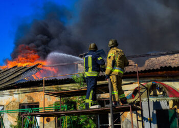 Esta fotografía tomada y publicada por el Servicio de Emergencia de Ucrania el 19 de septiembre de 2023 muestra a los bomberos apagando un incendio en un almacén después de un bombardeo en Kherson.