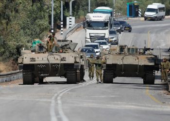 Soldados israelíes en vehículos blindados conducen por una calle cerca de la ciudad norteña de Kiryat Shmona, cerca de la frontera con el Líbano, el 13 de octubre de 2023. - Israel bombardeó una región fronteriza en el sur del Líbano, dijeron dos fuentes de seguridad libanesas, después de que se produjera una explosión en la valla fronteriza, según el ejército israelí. (Foto de Jalaa MAREY / AFP)
