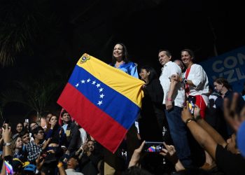 Venezuelan presidential pre-candidate for the opposition Vente Venezuela party, Maria Corina Machado (C) celebrates the results of the opposition's primary elections at her party headquarters in Caracas on October 22, 2023. - Venezuela's opposition is voting in primaries that will select a candidate to face President Nicolas Maduro in the elections next year. (Photo by Federico PARRA / AFP)