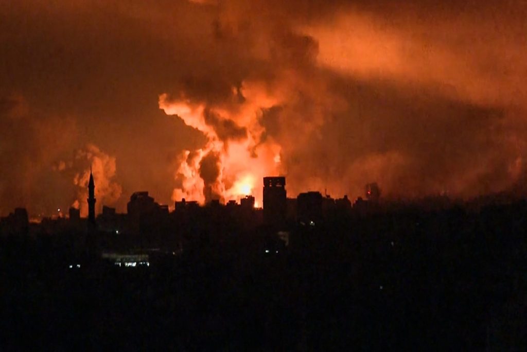Esta imagen tomada de un material de AFP TV muestra bolas de fuego y humo elevándose sobre la ciudad de Gaza durante un ataque israelí el 27 de octubre de 2023, mientras continúan las batallas entre Israel y el movimiento palestino Hamás. - El ejército israelí llevó a cabo la tarde del 27 de octubre bombardeos de una intensidad "sin precedentes" desde el inicio de la guerra en el norte de la Franja de Gaza, en particular en la ciudad de Gaza, según imágenes de la AFP y del movimiento Hamás. (Foto de AFP)