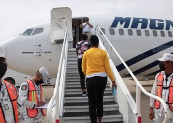 Migrantes haitianos abordando un avión de la línea aérea mexinaca Magni. Foto de referencia tomada de El País, México.