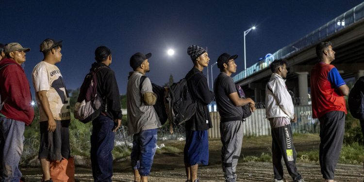 29 DE SEPTIEMBRE: Bajo la luna llena, inmigrantes venezolanos hacen fila para ser procesados por agentes fronterizos de Estados Unidos a principios del 29 de septiembre de 2023 en Eagle Pass, Texas. Un grupo de más de 500 inmigrantes, en su mayoría venezolanos, había cruzado el Río Grande durante la noche y agentes de la Patrulla Fronteriza les permitieron ingresar a Estados Unidos para presentar solicitudes de asilo. John Moore/Getty Images/AFP (Foto de JOHN MOORE / GETTY IMAGES NORTEAMÉRICA / Getty Images vía AFP)