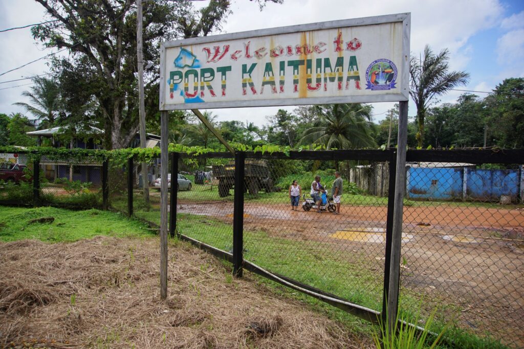 Imagen de un cartel de bienvenida en el aeropuerto de Port Kaituma en Guyana, tomada el 22 de septiembre de 2022. A pesar de la disputa con Guyana, la región del Esequibo es un destino de migración procedente de Venezuela. Guyana defiende un límite establecido en 1899 por un tribunal de arbitraje de París, mientras Venezuela reclama el Acuerdo de Ginebra, firmado en 1966 con el Reino Unido antes de la independencia guyanesa, que sentó las bases para una solución negociada e ignoraba el tratado anterior. Pero el gobierno guyanés impulsa un proceso en la Corte Internacional de Justicia (CIJ) para ratificar las fronteras actuales y poner fin a la disputa. (Foto de Patrick FORT / AFP)