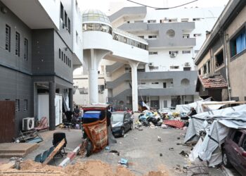 FOTO TOMADA DURANTE UN RECORRIDO CONTROLADO Y POSTERIORMENTE EDITADA BAJO LA SUPERVISIÓN DEL MILITAR ISRAELÍ-- Los palestinos se reúnen frente a uno de los departamentos del complejo hospitalario Al-Shifa en la ciudad de Gaza, en el norte de la Franja de Gaza, en medio de continuas batallas entre Israel y el Grupo militante palestino Hamás, el 22 de noviembre de 2023. (Foto de Ahikam SERI / AFP)