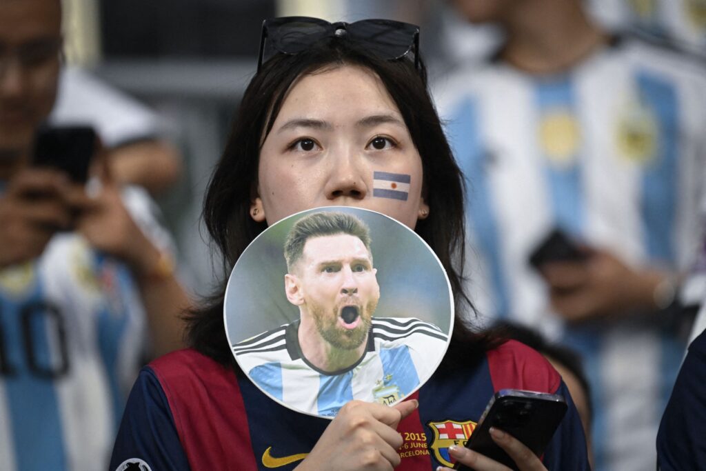 Un aficionado al fútbol sostiene un abanico con la imagen del jugador argentino Lionel Messi impresa antes de un partido amistoso entre Australia y Argentina en el estadio de los trabajadores de Beijing el 15 de junio de 2023. (Foto de WANG Zhao / AFP)