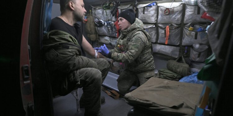 La médica militar ucraniana Vasylyna (R), de 28 años, de la octogésima brigada separada de Asalto Aéreo trata a un militar herido en un vehículo de evacuación médica en un área no revelada en la región de Donetsk, el 30 de noviembre de 2023, en medio de la invasión rusa a Ucrania. (Foto de GENYA SAVILOV/ AFP)