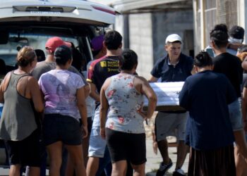 Un hombre lleva el ataúd de uno de los cuatro niños asesinados por hombres armados en Guayaquil, Ecuador, el 12 de diciembre de 2023. - Cuatro niños, incluido un bebé de cinco meses, murieron dentro de su casa en Ecuador cuando hombres armados entraron y abrieron fuego. sobre la familia, dijeron las autoridades el martes. (Foto de Gerardo MENOSCAL/AFP)