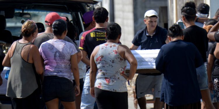 Un hombre lleva el ataúd de uno de los cuatro niños asesinados por hombres armados en Guayaquil, Ecuador, el 12 de diciembre de 2023. - Cuatro niños, incluido un bebé de cinco meses, murieron dentro de su casa en Ecuador cuando hombres armados entraron y abrieron fuego. sobre la familia, dijeron las autoridades el martes. (Foto de Gerardo MENOSCAL/AFP)