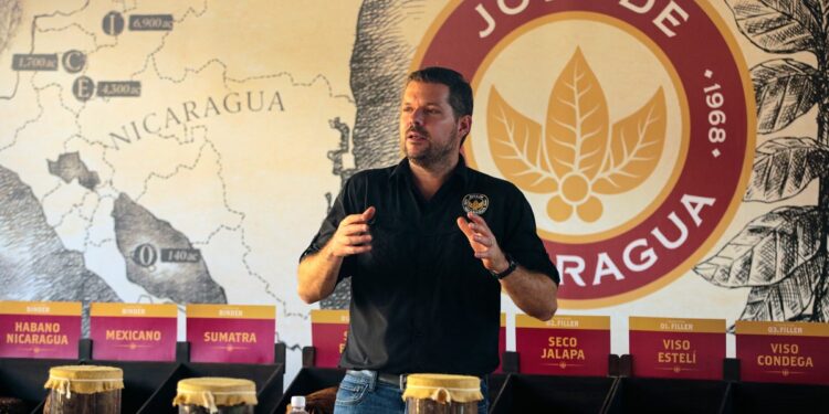 Juan Martinez, President of the tobacco company Joya de Nicaragua, speaks to tourists during a tobacco festival called "Puro Sabor" in Esteli, Nicaragua on January 24, 2024. - Nicaraguan cigars are desired because the tobacco is grown in volcanic soils and because of its manufacturing process, according to tobacco growers, merchants and consumers who attend the 11th Puro Sabor Festival in the city of Esteli, about 150 km north of Managua. "Nicaraguan tobaccos all have a strong flavor stability, they are rich in flavors, they have a very good body, they are round, they are tobaccos that are sweet, some are 'spicy', and they always have a very important characteristic and that is that the draw and the way they burn is perfect", Colombian Andres Diaz Cote, 57, a regular cigar smoker for 25 years, told AFP. (Photo by Oswaldo RIVAS / AFP)