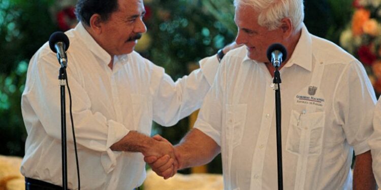 El presidente nicaragüense Daniel Ortega (izq.) le da la mano a su homólogo panameño Ricardo Martinelli durante una reunión en la casa presidencial en Managua, el 16 de marzo de 2012. Martinelli se encuentra en una visita oficial a Nicaragua. AFP FOTO/ELMER MARTINEZ (Foto de ELMER MARTINEZ / AFP)