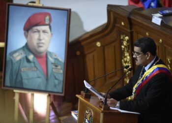 (FILES) Venezuelan President Nicolas Maduro speaks before the Constituent Assembly near a portrait of late Venezuelan President Hugo Chavez to announce measures to alleviate the serious economic crisis, at the Federal Legislative Palace in Caracas on January 14, 2019. - "Chavez lives, Carajo! The Fatherland continues!" a soldier shouts every day at 4.25 p.m. at the Caracas mountain barracks during the cannon-firing ceremony in memory of the death on March 5, 2013 at 4.25 p.m. of Hugo Chavez, who became President on February 2, 1999, just 25 years ago. (Photo by Federico PARRA / AFP)