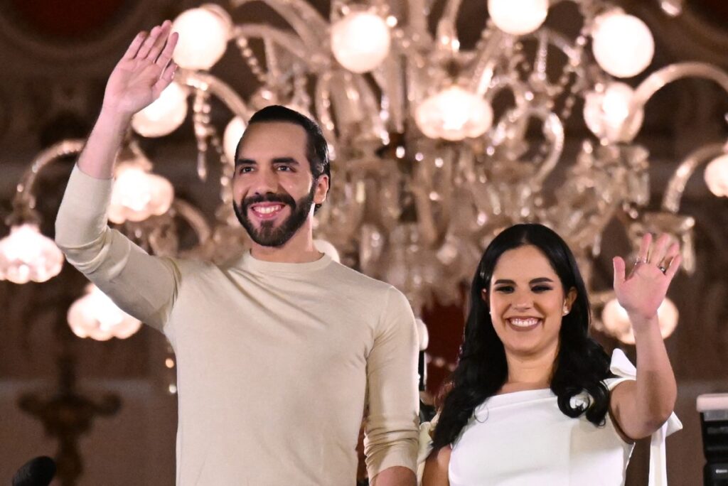 El presidente salvadore&ntilde;o Nayib Bukele saluda a sus partidarios junto a su esposa Gabriela Rodr&iacute;guez despu&eacute;s de las elecciones presidenciales y legislativas en San Salvador el 4 de febrero de 2024. - Estallaron fuegos artificiales en la capital de El Salvador cuando el presidente antipandillas Nayib Bukele afirm&oacute; haber ganado la reelecci&oacute;n con m&aacute;s de 85 por ciento de votos emitidos: "un r&eacute;cord en toda la historia democr&aacute;tica del mundo". (Foto de Marvin RECINOS / AFP)