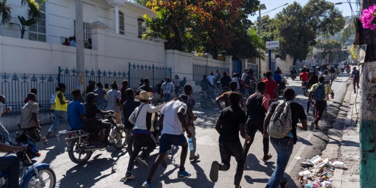 Los manifestantes corren en la calle durante una manifestación después de un ataque de pandillas contra una comisaría de policía que dejó seis agentes muertos, en Puerto Príncipe, Haití, el 26 de enero de 2023. Los ataques, que dejaron seis agentes muertos, ocurrieron el 25 de enero en la localidad de Liancourt, cuando los agentes tuvieron que repeler cuatro ataques de los pistoleros que intentaban tomar la comisaría, según noticias locales. (Foto de Richard Pierrin / AFP)