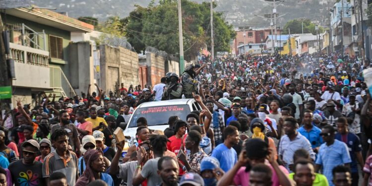 La gente celebra la llegada de la Brigada de Seguridad de Áreas Protegidas (BSAP, por sus siglas en inglés) de la agencia paramilitar y ambiental durante una manifestación que pide la salida del primer ministro haitiano, Ariel Henry, en Puerto Príncipe el 6 de febrero de 2024. - El gobierno de Haití el El 5 de febrero de 2024 anunció una ofensiva contra el BSAP, cuyos agentes fuertemente armados han ganado poder recientemente y han sido culpados de violentos enfrentamientos con la policía la semana pasada. (Foto de Richard PIERRIN / AFP)