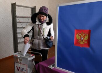 Una mujer deposita su voto en un colegio electoral durante la votación anticipada para las elecciones presidenciales de Rusia en la aldea de Sennaya Guba, República de Karelia, el 10 de marzo de 2024. (Foto de NATALIA KOLESNIKOVA / AFP)