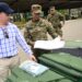 US Deputy Chief of Mission John Barrett (L) and a member of Panama's General Director of the National Border Service (SENAFRONT) inspect camping gear donated by the US government at the National Border Service Base in Meteti, Darien Province, Panama, on March 11, 2024. - The United States donated half a million dollars worth of tents, cots, and other equipment on Monday to assist migrants crossing the Panamanian jungle, following the departure of the NGO Médecins Sans Frontières (MSF). (Photo by MARTIN BERNETTI / AFP)