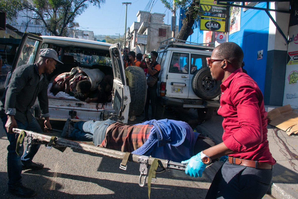 Paramédicos transportan el cuerpo de una persona que estaba entre una docena asesinada en la calle por pandilleros, en Pétionville, Puerto Príncipe, Haití, el 18 de marzo de 2024. - El jefe de la agencia de la infancia de la ONU ofreció una evaluación terrible el 17 de marzo de 2024 de la situación caótica en Haití, diciendo que era "casi como una escena de 'Mad Max'", que representaba un futuro post-apocalíptico violento y sin ley. (Foto de Clarens SIFFROY / AFP)