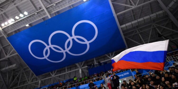 Un espectador ondea la bandera de Rusia durante el partido de hockey sobre hielo de la ronda preliminar masculina entre los atletas olímpicos de Rusia y Eslovenia durante los Juegos Olímpicos de Invierno de Pyeongchang 2018 en el Centro de Hockey de Gangneung en Gangneung el 16 de febrero de 2018. - Los jefes olímpicos anunciaron el 19 de marzo de 2024 que los atletas rusos y bielorrusos que compitan en los Juegos de París de este verano bajo bandera neutral no podrán participar en la ceremonia inaugural. Los atletas neutrales de ambos países "no participarán en el desfile de delegaciones y equipos durante la ceremonia de apertura, ya que son atletas individuales", dijo el director del COI, James McCloud, después de una reunión de la junta ejecutiva del Comité Olímpico Internacional en Lausana. (Foto de Brendan Smialowski / AFP)