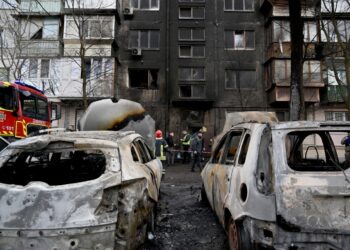 Ukrainian rescuers stand outside of a five-storey residential building after a missile attack, in Kyiv on March 21, 2024, amid the Russian invasion in Ukraine. - Ukrainian air defence forces shot down "about three dozen enemy missiles, including ballistic missiles, over Kyiv and in the vicinity of the capital," the city's military administration said on Telegram, adding that the raid had lasted three hours. (Photo by Sergei SUPINSKY / AFP)