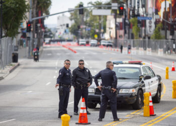 Agentes de policía bloquean una calle cerca del Dolby Theatre antes de la 96ª edición de los Premios Anuales de la Academia, en Los Ángeles, California, el 10 de marzo de 2024. (Foto de RINGO CHIU / AFP)