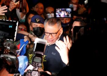 Ecuadorean former vice president (2013-2017) Jorge Glas --who was serving a sentence for receiving millions in bribes from Brazil's Odebrecht-- is surrounded by media members after being released from prison in Quito on November 28, 2022. Ecuador's former vice president Jorge Glas, who since 2017 was serving a sentence for corruption, was released on parole on Monday after a judge issued a precautionary measure in his favor. (Photo by Galo Paguay / AFP)