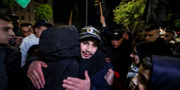 Un prisionero recién liberado (R) abraza a un familiar durante una ceremonia de bienvenida tras la liberación de prisioneros palestinos de las cárceles israelíes