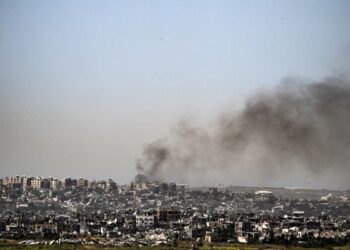 Esta fotografía tomada desde la frontera sur de Israel con la Franja de Gaza muestra humo ondeando detrás de los edificios destruidos debido a los ataques israelíes en el territorio palestino asediado el 2 de abril de 2024, en medio del conflicto en curso entre Israel y el grupo militante Hamás. (Foto de RONALDO SCHEMIDT / AFP)