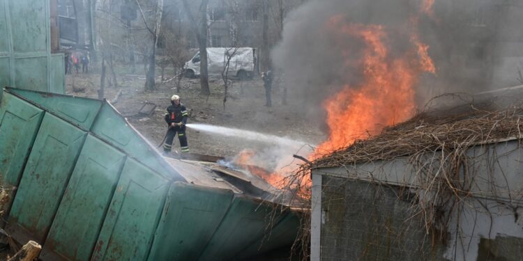 Los bomberos apagan un incendio en el lugar de un ataque con misiles en el centro de Járkov, el 7 de abril de 2024, en medio de la invasión rusa en Ucrania. (Foto de SERGEY BOBOK / AFP)