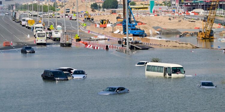 Los coches quedan varados en una calle inundada en Dubái tras las fuertes lluvias del 18 de abril de 2024. - Las gigantescas autopistas de Dubái quedaron obstruidas por las inundaciones y su principal aeropuerto estaba sumido en el caos mientras el centro financiero de Oriente Medio permanecía paralizado el 18 de abril, un día después de la tormenta más intensa. lluvias registradas. (Foto de Giuseppe CACACE / AFP)