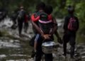 Un migrante haitiano carga a un niño pequeño mientras cruza la selva del Tapón del Darién, cerca de Acandí, departamento de Chocó, Colombia, en dirección a Panamá, el 26 de septiembre de 2021, en su camino para intentar llegar a Estados Unidos.