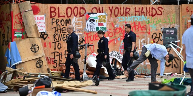 Police patrol as workers clean up the University of California, Los Angeles (UCLA) campus after police evicted pro-Palestinian students, in Los Angeles, California, early on May 2, 2024. - Hundreds of police tore down protest barricades and began arresting students early Thursday at the University of California, Los Angeles - the latest flashpoint in an eruption of protest on US campuses over Israel's war against Hamas in Gaza. (Photo by Frederic J. Brown / AFP)