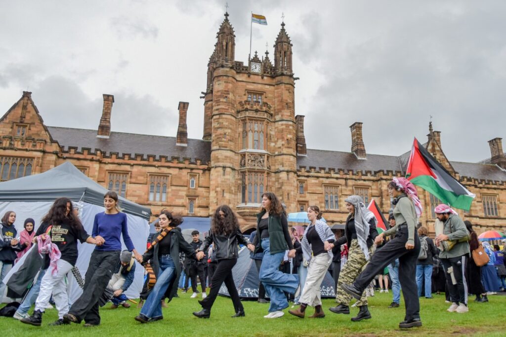 Miembros de la comunidad palestina australiana gritan consignas en el campamento de protesta palestino de la Universidad de Sydney en Sydney el 3 de mayo de 2024 (Foto de Ayush Kumar / AFP).
