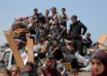Los palestinos que huyeron de Rafah, en el sur de la Franja de Gaza, viajan con sus pertenencias en la parte trasera de un camión, cuando llegan para refugiarse en Deir el-Balah, en la parte central del territorio palestino, el 12 de mayo de 2024, en medio del conflicto en curso entre Israel y el grupo militante Hamás. (Foto de AFP)