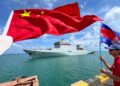 La gente ondea banderas de Camboya (derecha) y China (izq.) mientras el buque escuela chino Qijiguang se prepara para atracar con una pancarta que dice "Traer paz y amistad para encontrar buenos amigos" durante una ceremonia de bienvenida en el puerto de Sihanoukville, en la provincia de Preah Sihanouk, el 19 de mayo. , 2024. - Dos buques de guerra chinos atracaron en Camboya el 19 de mayo de 2024 como parte de los mayores ejercicios militares conjuntos jamás realizados con la nación del sudeste asiático. (Foto de AFP)