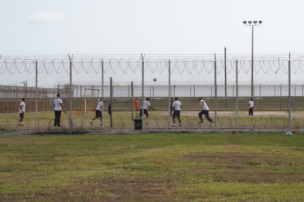 Los detenidos juegan afuera durante un recorrido mediático por el Centro de Detención de Port Isabel (PIDC), organizado por las Operaciones de Detención y Deportación de Harlingen (ERO) del Servicio de Inmigración y Control de Aduanas (ICE) de los Estados Unidos, en Los Fresnos, Texas, el 10 de junio de 2024. - Detrás de púas Cercas de metal cubiertas con alambre de púas, hombres juegan voleibol y baloncesto en un centro de detención en Texas, pasando el tiempo mientras esperan saber si se les permitirá permanecer en los Estados Unidos. Se encuentran entre los más de 1.000 alojados en esta antigua base naval en la ciudad estadounidense de Los Fresnos, a sólo unos kilómetros de la frontera con México, que todos cruzaron ilegalmente. (Foto de Verónica G. Cárdenas/PISCINA/AFP)